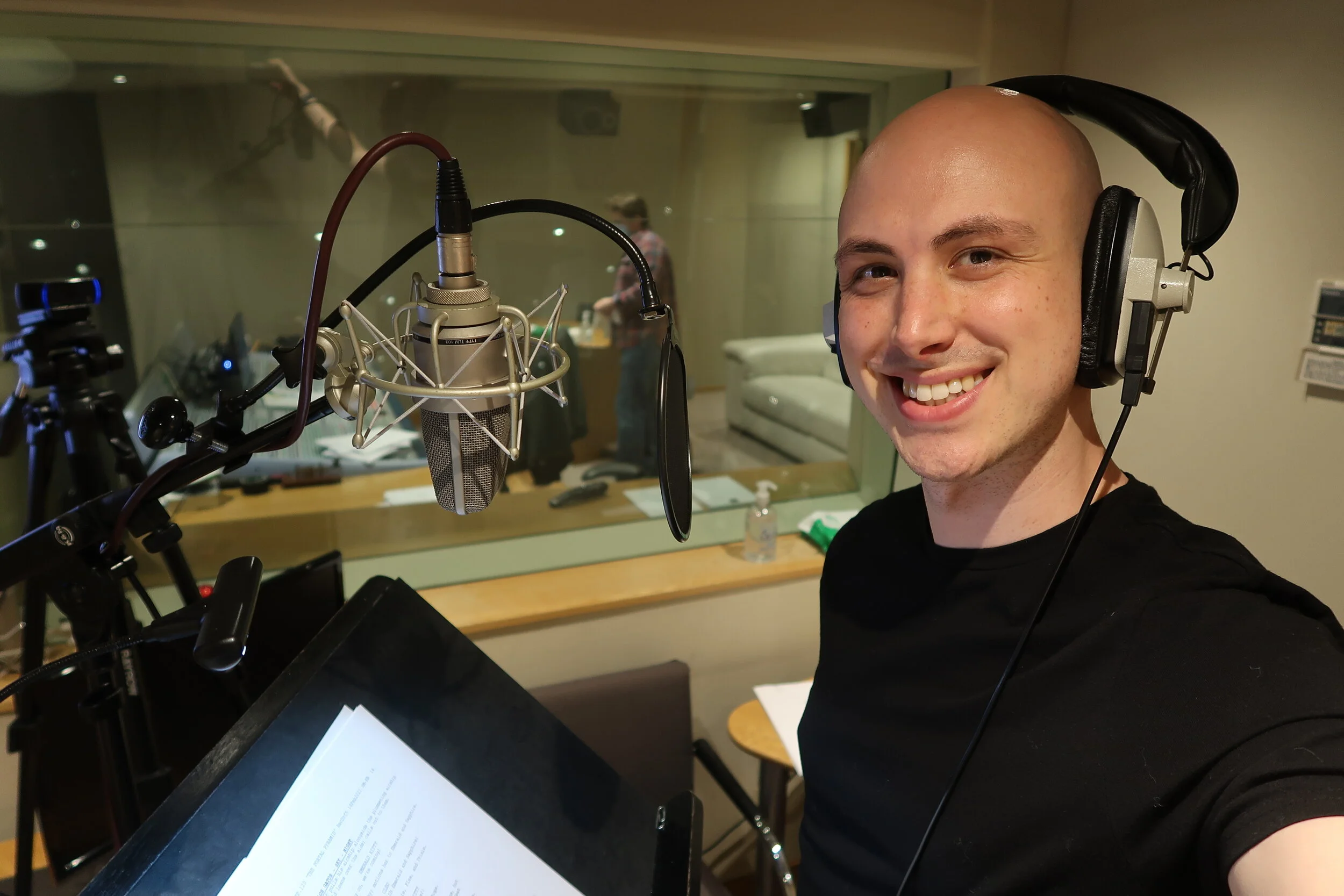 Taylor Clarke-Hill smiling at the microphone in his home recording studio