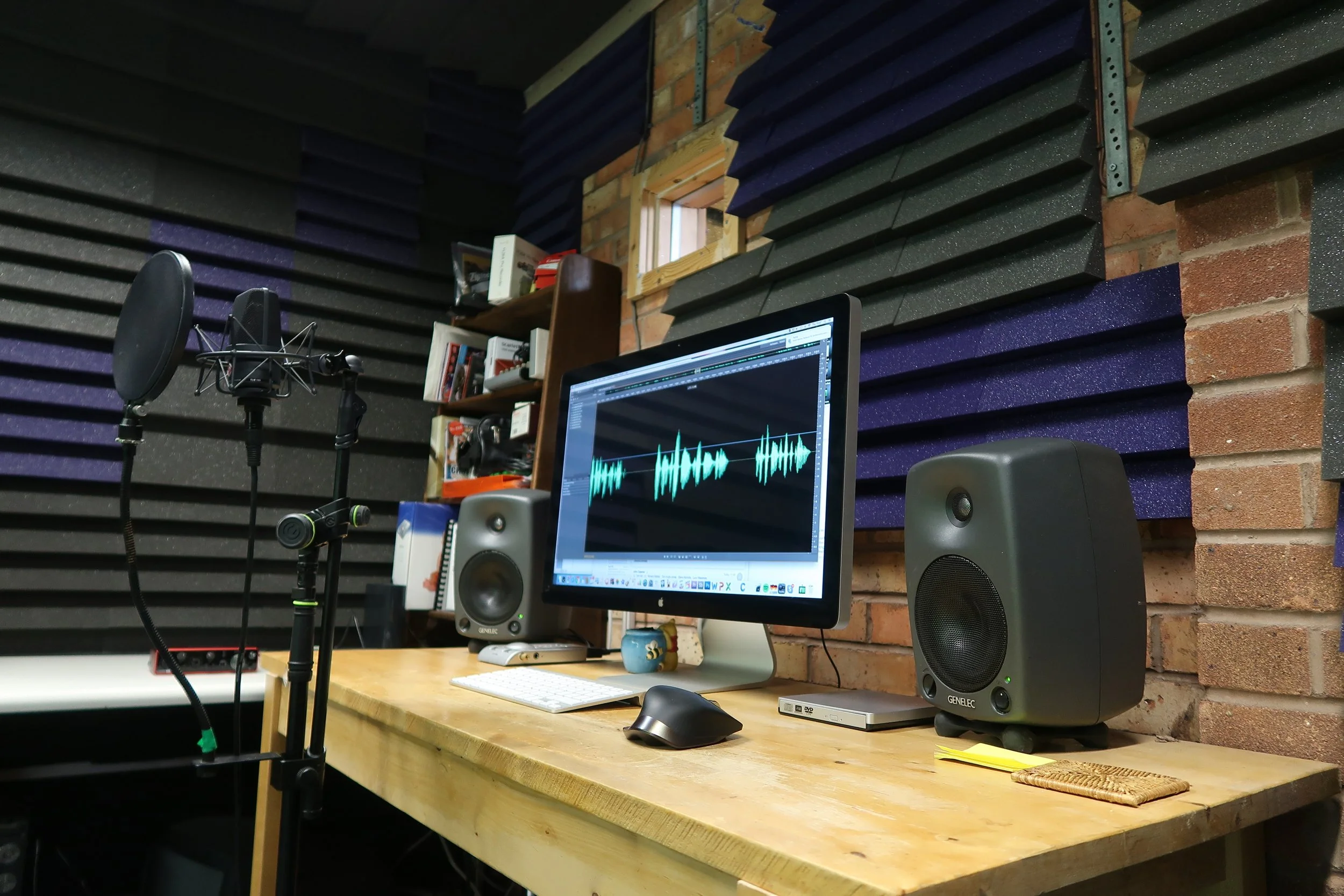 Taylor's soundproofed home recording studio with monitors and microphone